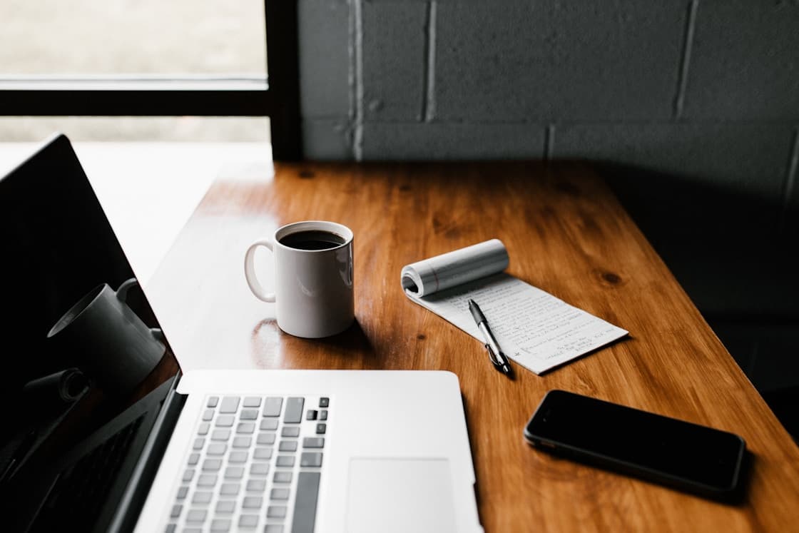 A welcoming workspace with a table, people working, and coffee